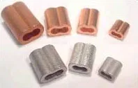 Small metal crimp sleeves (copper and silver tones) used to terminate or join electrical wires, arranged in a row.